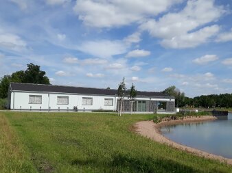 Foto: Öffentliche Toilette: Café am See © Stadtverwaltung Erfurt länglicher Flachbau mit weißer Außenfassade am Teich